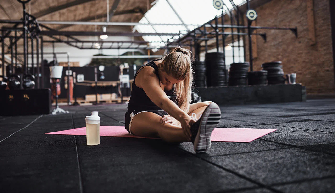 Female athlete doing stretches in gym before a workout