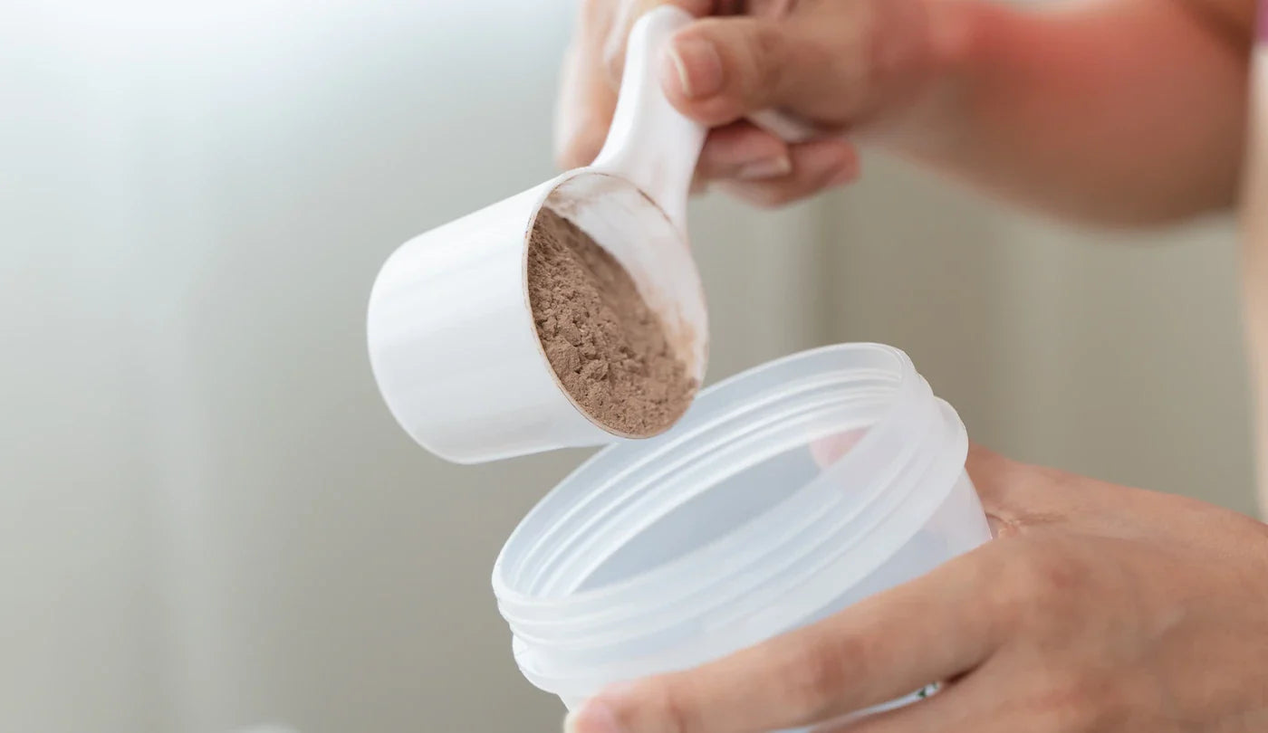 Woman scooping Protein Powder in to a Shaker