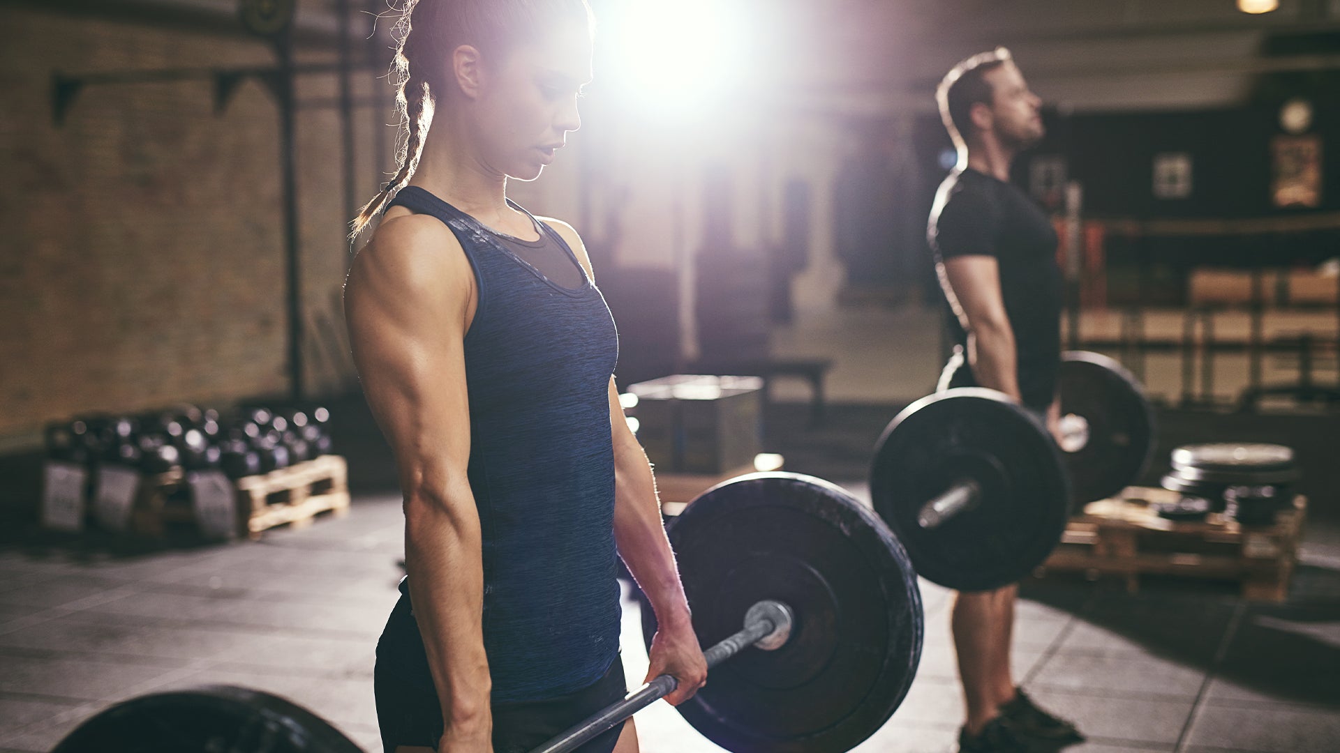 Female and Male Athlete performing Deadlifts