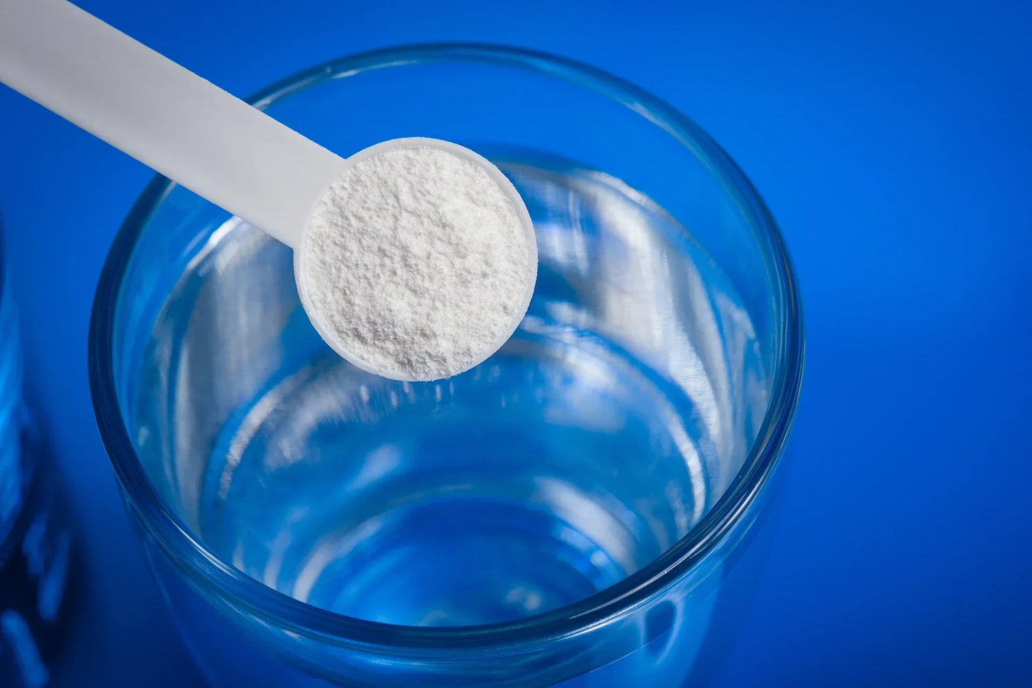 Creatine Powder being scooped in to a glass of water