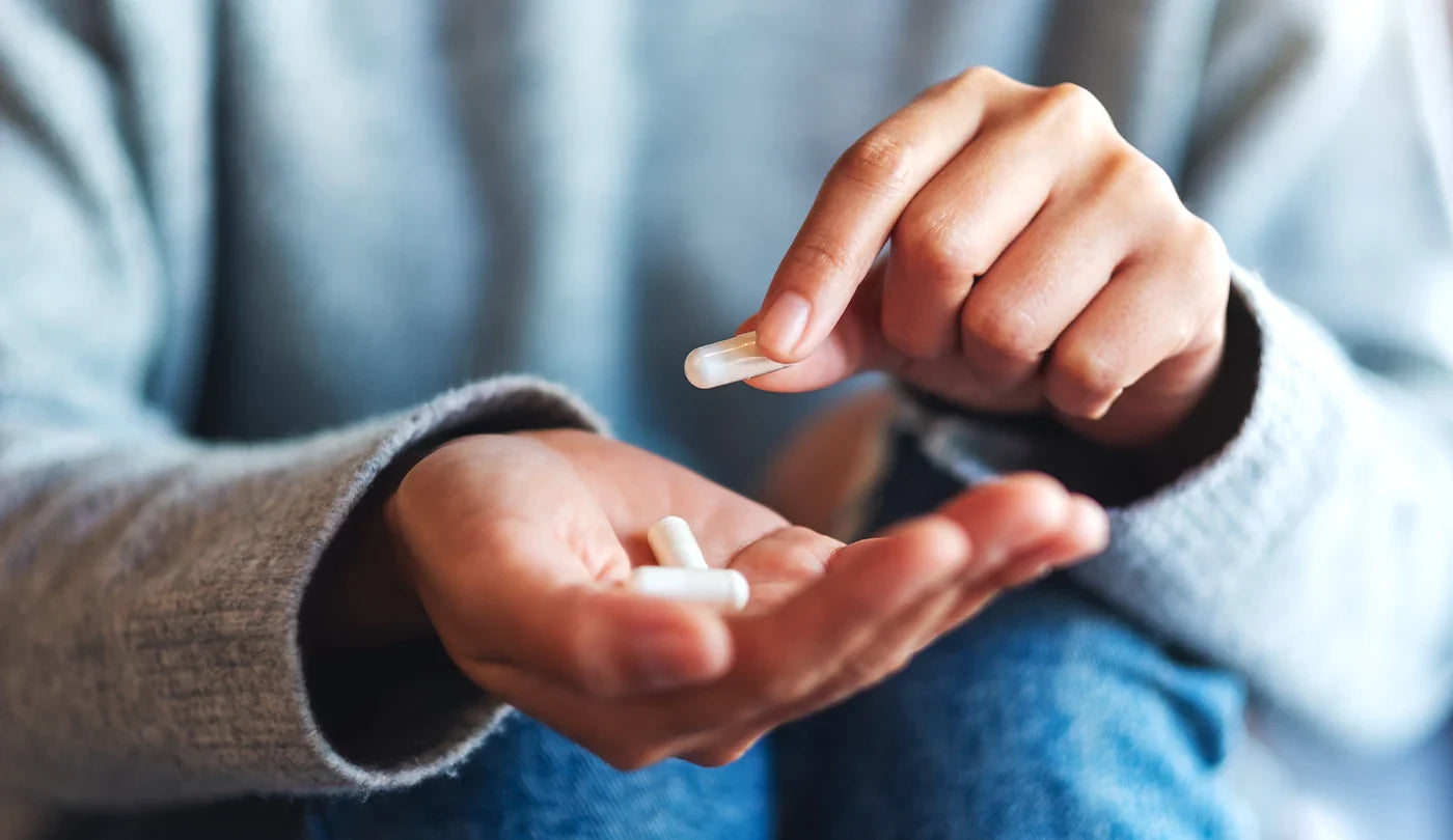 Woman holding supplement capsules