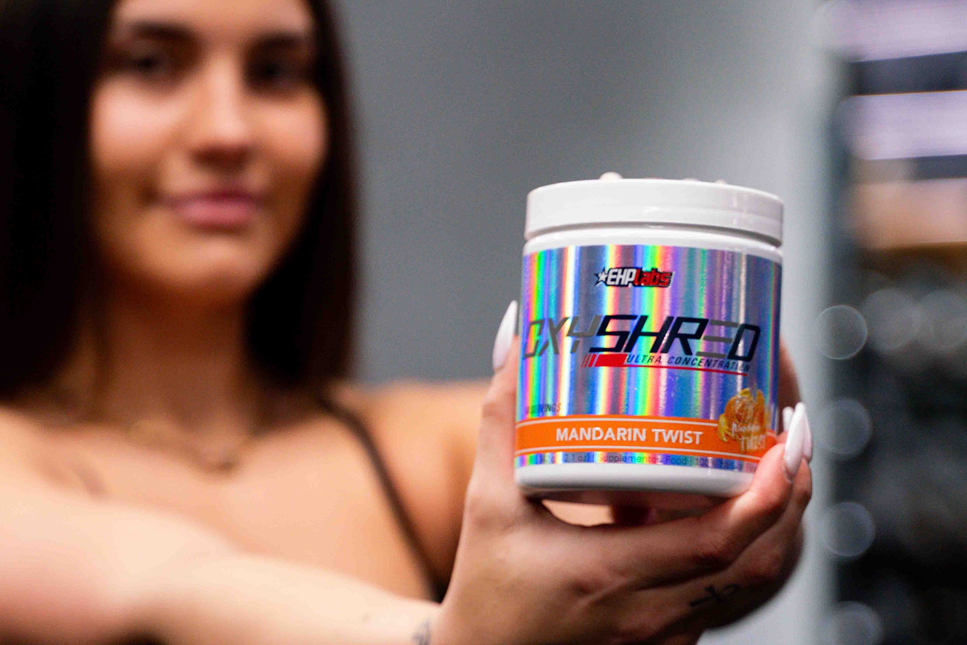 Woman holding a tub of EHP Labs Oxyshred 