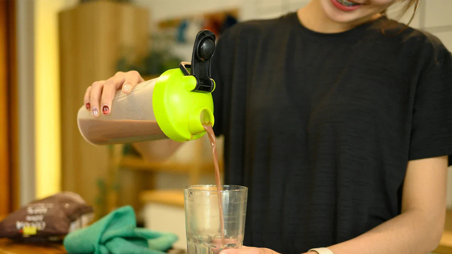 Woman pouring a protein shake in to a glass