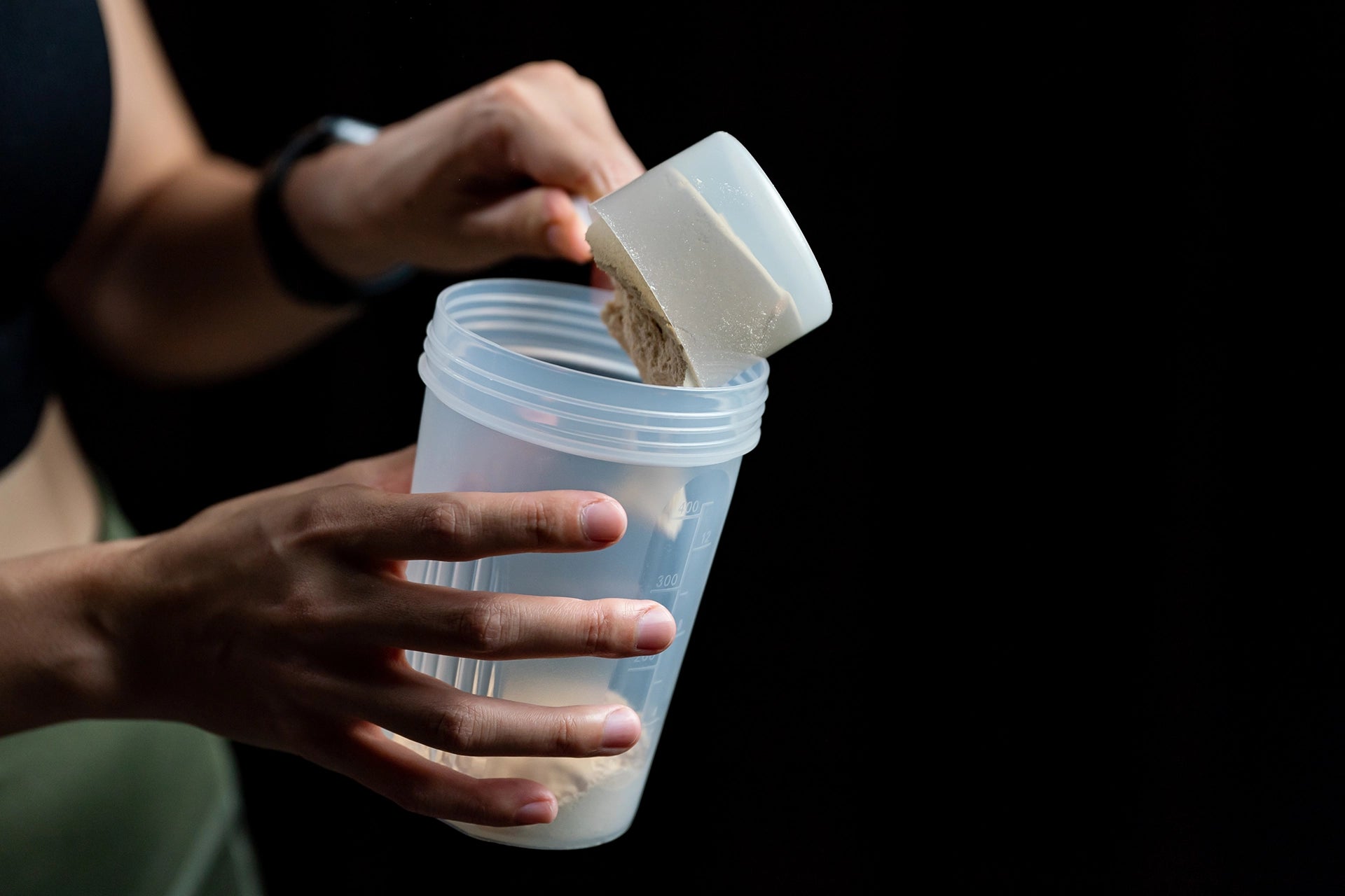 Woman scooping protein into a shaker