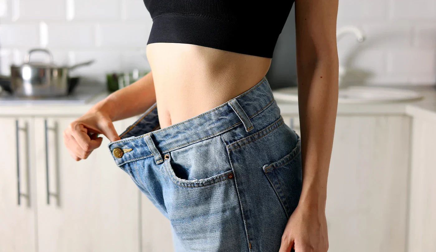 Woman in loose jeans after weight loss